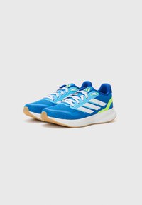 Sportliche Schuhe mit einem atmungsaktiven blauen Mesh-Obermaterial, weißen Streifen, neon-grünen Akzenten und einer Gummisohle. Sie verfügen über einen gepolsterten Schaft und Schnürsenkel.