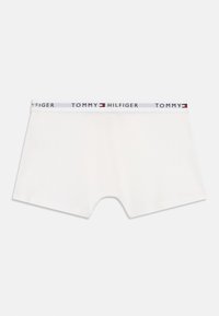 Hvide Tommy Hilfiger drengetrusser med mærke-elastik i taljen og uden synlige mønstre eller designs.