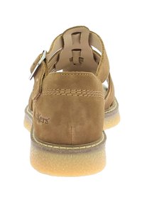 Bruine suède sandalen met een open achterkant, verstelbare zilveren gesp, zichtbare stiksels en een gestructureerde rubberen zool.