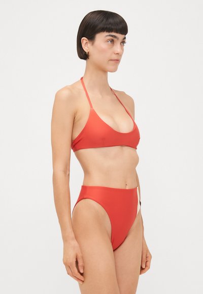 Sarkans bikini komplekts ar trīsstūrveida krūšturi ar plānām siksnām un augsto jostasvietu apakšdaļām, gluda tekstūra, minimālisma dizains, nav rakstu.