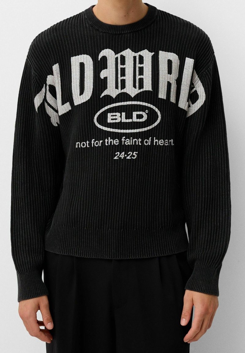 Pull noir à côtes avec texte blanc de style gothique "OLD WRLD", un logo ovale "BLD" et un texte plus petit "pas pour les âmes sensibles 24:25" sur le devant.