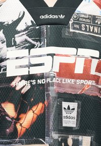 Αθλητική φανέλα Adidas με λογότυπο ESPN και το σύνθημα «Δεν υπάρχει καλύτερο μέρος από τον αθλητισμό», με γραφικά εκτυπωμένα αθλητές και αθλητικά αντικείμενα.
