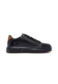 Sneaker in pelle nera con tab di tacco marrone, lacci neri e suola spessa nera con texture sottile, mostrato in profilo laterale su sfondo bianco.