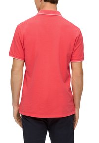 Czerwona koszulka polo z krótkim rękawem, kontrastującym białym kołnierzykiem i wykończeniem rękawów, uszyta z miękkiego materiału, widok z tyłu.