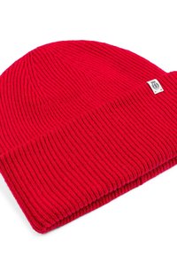 Red knitted beanie with ribbed texture and a folded cuff. Includes a small label detail. Material appears soft and warm.