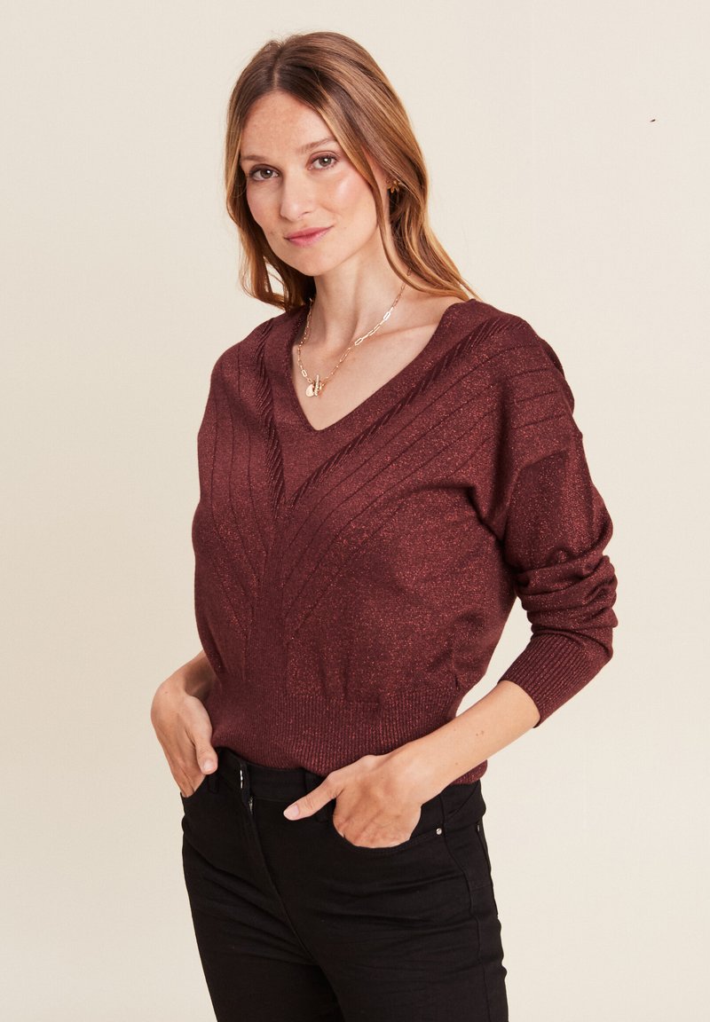 Bordeaux metallic sweater met een diepe V-hals, geribbelde manchetten en een getailleerde taille. Heeft verticale textuurpatronen over de voorkant.