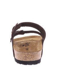 Sandale en cuir marron avec semelle en liège et semelle en caoutchouc noir. Caractéristiques : larges brides avec une accent floral. Taille 42 imprimée sur la semelle intérieure.