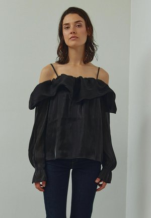 Zwarte off-shoulder blouse met een gerimpelde halslijn, gemaakt van glanzende stof, met lange, geplooide mouwen en een losse pasvorm.
