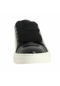Baskets noires avec un embout en cuir texturé, dessus en tissu et lacets plats noirs. Semelle en caoutchouc blanc avec une texture en galets.