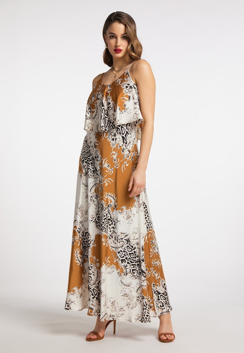 Maxikleid mit einem braunen, weißen und schwarzen Blumenmuster. Es hat ein geschichtetes, gerafftes Oberteil und eine fließende Silhouette mit Spaghettiträgern.
