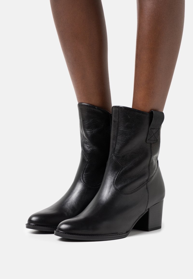 Zwarte leren enkellaarzen met een puntige neus, gestructureerde afwerking en een gematigde blokhak. Voorzien van zij-elastische panelen voor eenvoudig aan- en uittrekken.