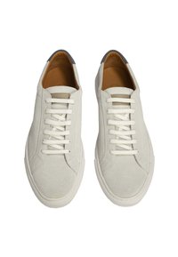 Sneakers in suede di colore grigio chiaro con lacci bianchi piatti, punta rotonda e soletta color tan. Presentano una suola in gomma liscia e un design minimalista.