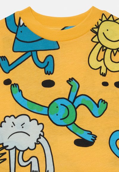 Geltona marškinėliai su komiksų personažais mėlyna, žalia ir juoda spalvomis. Apvalus kaklas, trumpomis rankovėmis ir žaismingais raštais su įvairiomis formomis.