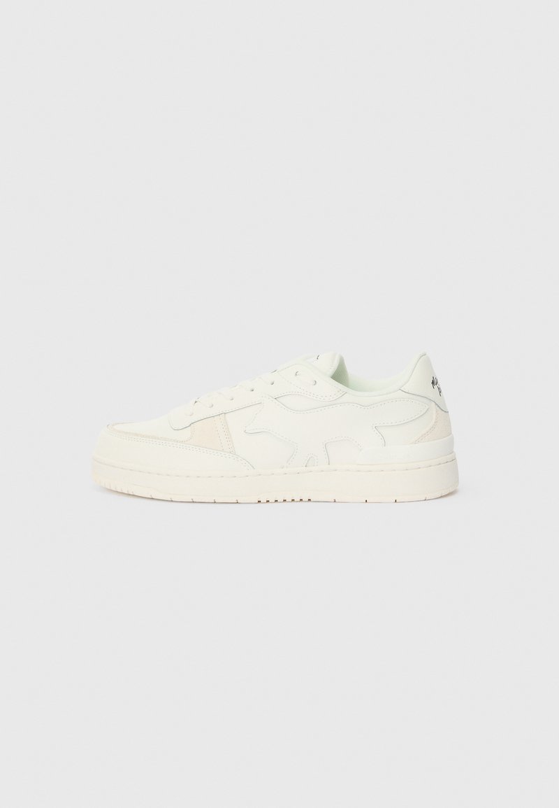 Λευκό δερμάτινο αθλητικό παπούτσι με υφασμάτινη σχεδίαση, διαθέτοντας ελαφρώς ανυψωμένη σόλα και διακριτικές μπεζ λεπτομέρειες στα πλευρικά πάνελ.