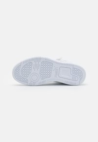Witte sneakerzool van gestructureerd rubber, met een hexagonaal patroon, een ronde pod en looplijnen voor verbeterde grip en ondersteuning.