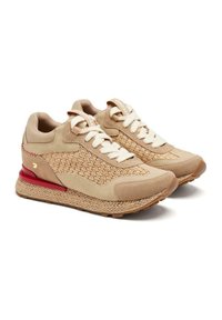 Sneaker beige con tomaia intrecciata, accenti in suede, punta rotonda, suola in gomma beige e un dettaglio rosso sul tallone. I lacci bianchi completano il look.