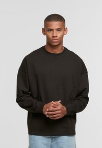 Black long-sleeve sweatshirt with a crew neck, made of cotton. Features dropped shoulders and ribbed cuffs. Simple, solid color design.