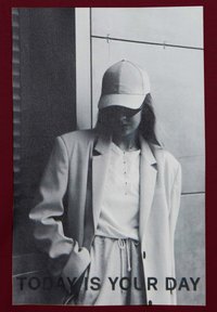 Gráfico en blanco y negro de una persona con un blazer de color claro, gorra y camisa blanca con botones, con el texto "HOY ES TU DÍA".