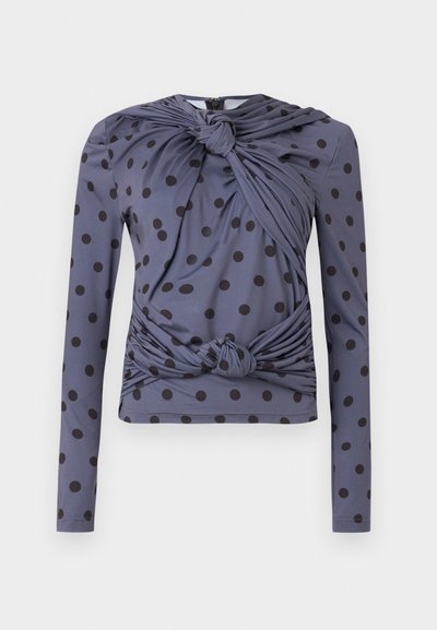 Μακρυμάνικη μπλούζα σε γκρι με μαύρα πουά, με σχέδιο στροφής υφάσματος στο μπροστινό μέρος και δεσίματα στη μέση.