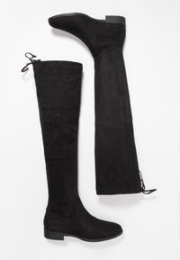 Black suede over-the-knee boots with a flat sole. Features include a fitted design, tie accents at the top, and smooth texture throughout.