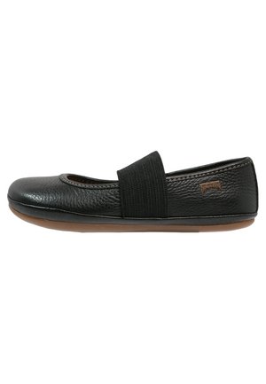 Zwarte leren platte schoen met ronde neus, brede elastische band over de wreef en een bruine zool.