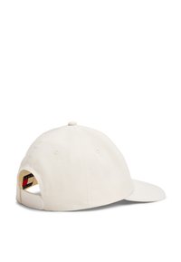 Casquette de baseball en crème, fabriquée à partir d'un tissu texturé. Elle possède une visière incurvée et une sangle ajustable à l'arrière avec un détail de logo.