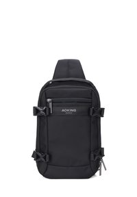 Zaino a spalla in tessuto nero con spallacci regolabili, tasche con zip esterne e fibbie laterali. Presenta il logo sul pannello frontale.