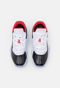 Zapatillas de lona negra con charol y malla blanca con acentos rojos. Las características incluyen una suela de goma, parte superior con cordones y el icónico logo de Jumpman.