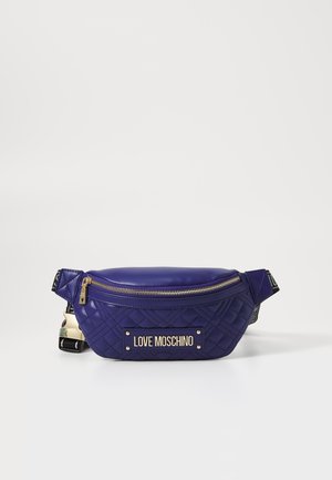 Purple quilted fanny pack with gold hardware and a logo plate. Features a zippered top and a textured fabric strap. Compact and sporty design.