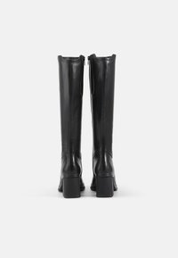 Black leather knee-high boots with a block heel, featuring a smooth texture and a zip closure at the back. Elegant and streamlined design.