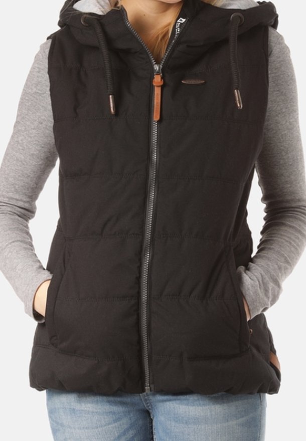 Schwarze Steppweste mit Kapuze, ausgestattet mit einem Reißverschluss, zwei Fronttaschen und braunen Lederakzenten. Wird über einem grauen Langarmshirt getragen.