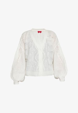 Biała dziergana kamizelka z dekoltem w serek, zapięciem na guziki i balonowymi rękawami. Posiada ażurowe wzory i teksturowane wykończenie.