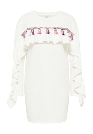 Biała bluzka z długim rękawem, ozdobiona falbaniastymi akcentami, różową lamówką oraz dekoracyjnymi frędzlami w odcieniach różu, fioletu i kremu na wysokości klatki piersiowej.