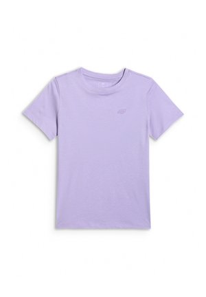 Dziewczyna z długimi ciemnymi włosami nosi różową czapkę z daszkiem tyłem do przodu, lawendowy t-shirt, szare spodnie dresowe z różowymi kokardkami, szarą bluzę zawiązaną w talii oraz sportowe buty.