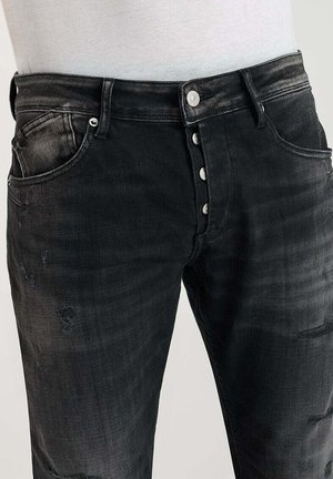 Zwarte denim jeans met een vervaagde afwerking, vijf knopen, steekzakken aan de voorkant en versleten details op de benen.