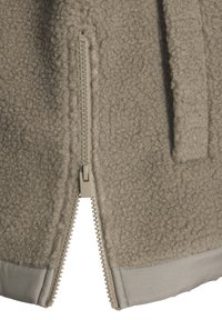 Fleecejacke in hellbeige mit strukturierter Oberfläche, ausgestattet mit einem silbernen Reißverschluss und einem glatten grauen Saum am unteren Rand.