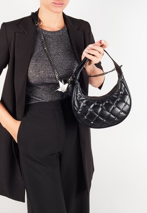 Sort quiltet håndtaske med sølvaccenter og kædehank, lavet af skinnende materiale. Sammen med en glitrende top og en strømlinet blazer.