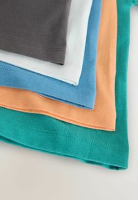 Tricouri din bumbac cu straturi, în culorile: gri, albastru deschis, aqua, portocaliu și teal. Toate au o textură netedă și tivuri cusute.