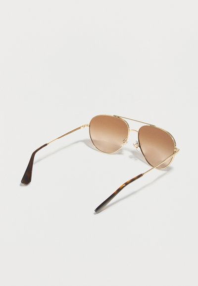 Αviator γυαλιά ηλίου με χρυσό πλαίσιο, καφέ φακούς με διαβάθμιση και άκρα ναών με σχέδιο χελώνας, σε λευκό φόντο.