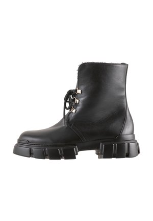 Black leather ankle boot with lace-up front, gold hardware accents, and a chunky rubber sole with textured grooves.