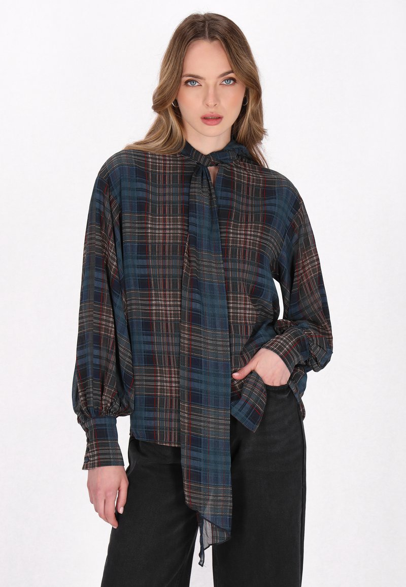 Blusa de cuadros de manga larga en azul oscuro, verde y rojo con cuello de lazo y corte relajado. Fabricada en una tela suave con un ligero brillo.