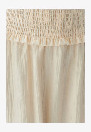 Heledbeez värvi kleit, mis on varustatud smockitud rinnaosaga koos volangidega ja voolava, tekstureeritud seelikuga. Kanga välimus on kerge ja veidi kortsus.