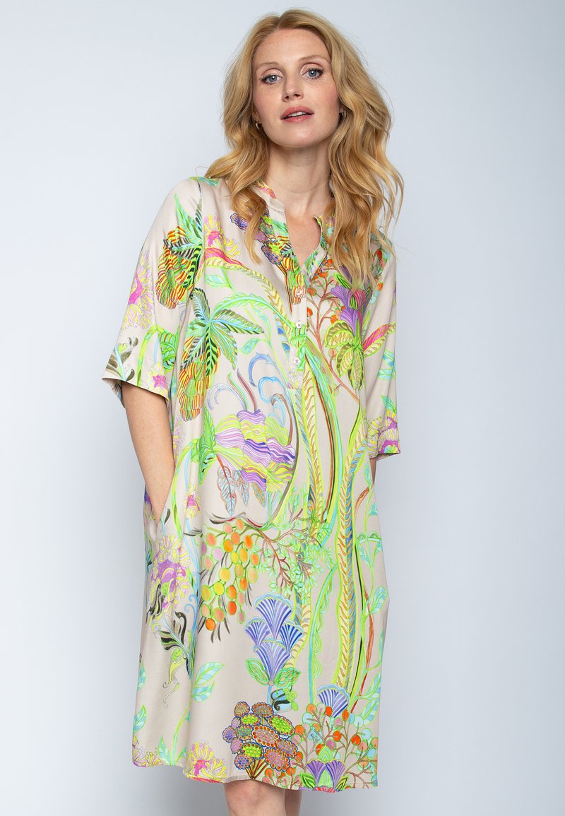 Helles beiges Kleid mit lebhaften, bunten Blumen- und Blattmustern. Es hat eine lockere Passform, kurze Ärmel und einen geknöpften Ausschnitt.
