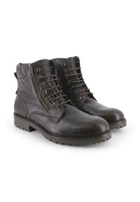 Botines de cuero marrón con cordones y cierre lateral, con un acabado texturizado y suela de goma con agarre antiderrapante.