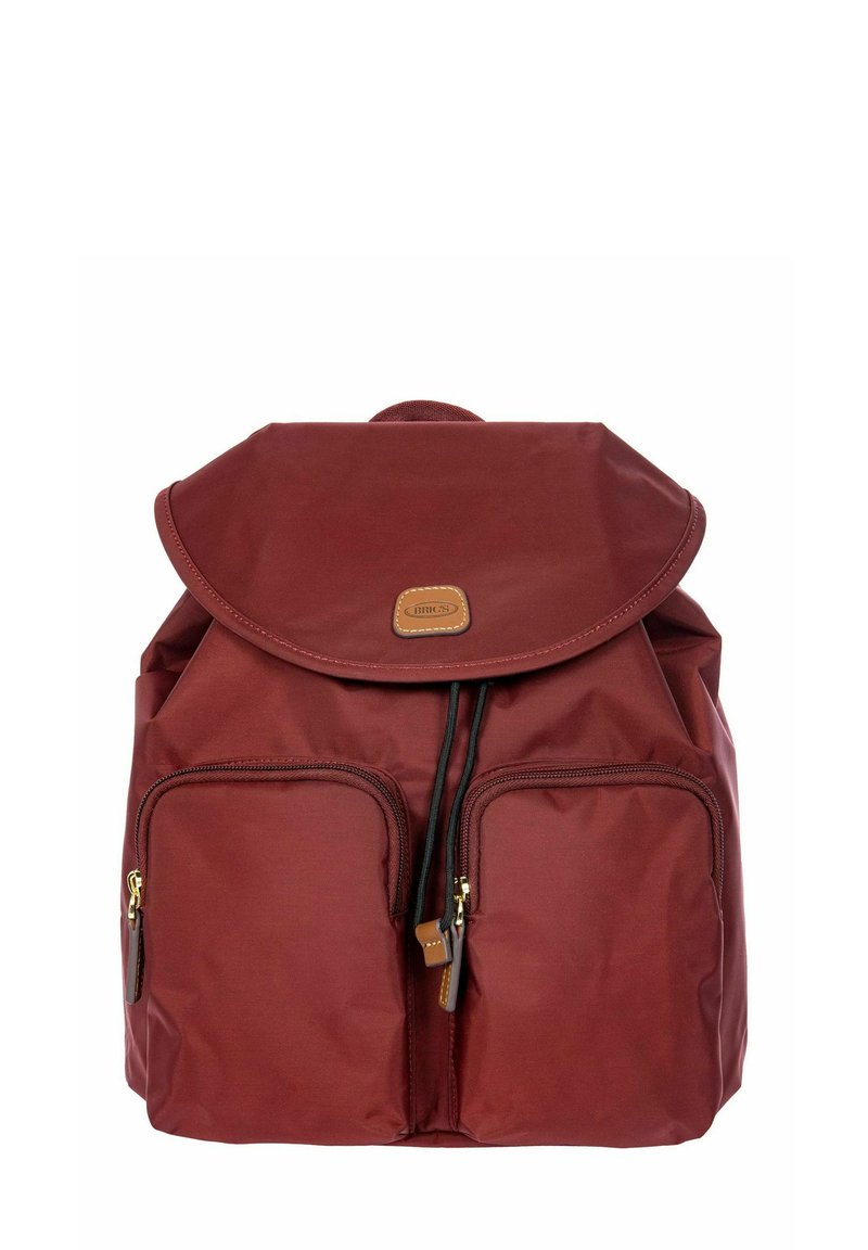 Zaino bordeaux con copertura a pattina, due tasche frontali con zip, chiusura a coulisse e un'etichetta in pelle beige sul davanti. Texture del tessuto liscia.
