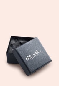 Svart, texturerad smyckesask med gångjärnslock, innehållande svart silkespapper. Vit logotyp "Sofia Milani Jewels" framtill.