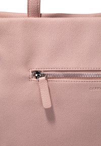 Borsa tote rosa con un'esterno in tessuto testurizzato, dotata di una tasca con zip con hardware metallico e un linguetta in pelle per un facile accesso.