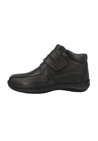 Botín de cuero negro hasta el tobillo con tira de Velcro, puntera redondeada, costuras en contraste y suela resistente. Cuello ligeramente acolchado para mayor comodidad.