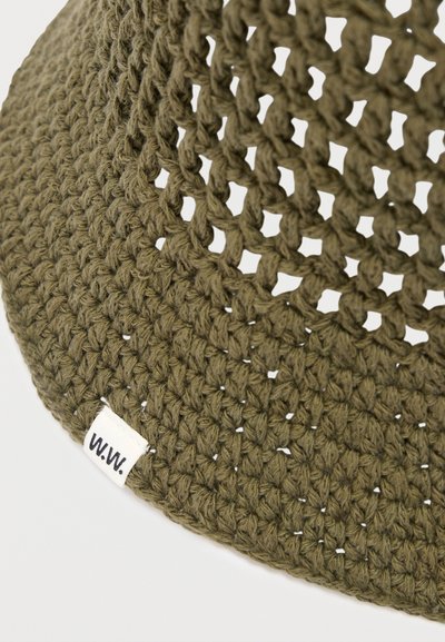 Πλεκτό υφαντό σε ελιά πράσινο με στρογγυλεμένο σχήμα, με τμήματα στενής και ανοιχτής ύφανσης, που διαθέτει μια μικρή λευκή ετικέτα με μαύρο κείμενο "W.W.".