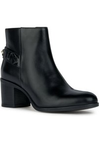 Bottine en cuir noir à finition lisse, talon bloc moyen et détail de sangle décorative sur le côté. Forme de bout arrondi.